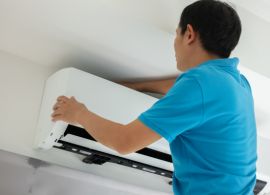Aircond technician cleaning air conditioner