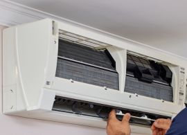 Aircond repair technician fixing unit