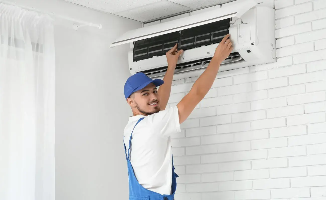 Professional aircond technician servicing air conditioning unit